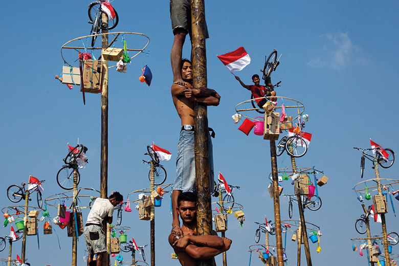 Men climb poles during Panjat-Pinang in Indonesia Men climb poles during Panjat-Pinang in Indonesia