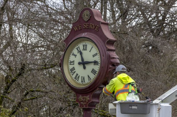 A close up of a city of Vancouver worker fixing an outdoor public clock at the Queen Elizabeth Park in Vancouver, British Columbia.